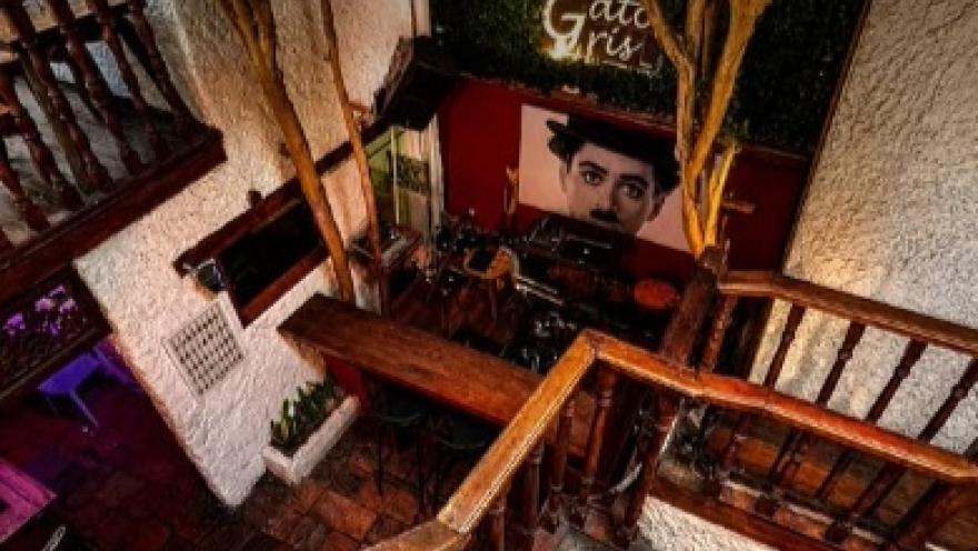 Interior of El Gato Gris, featuring wooden stairs, colonial decor, and a portrait on the wall.