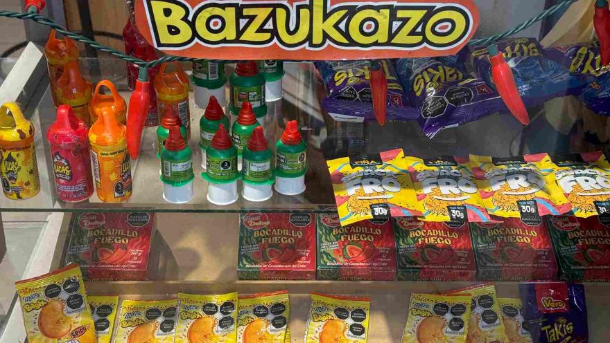 Exhibición de dulces, botanas y productos mexicanos en una vitrina identificada como Bazukazo.