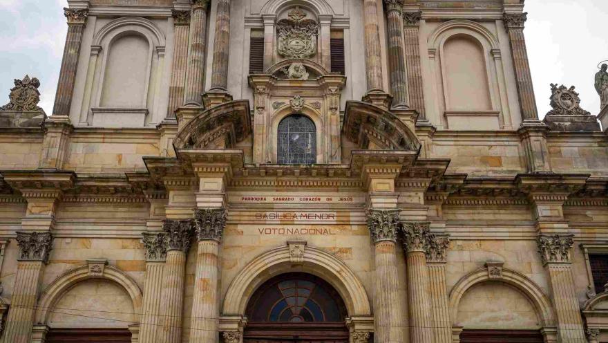 Detalle de la fachada de la Iglesia del Voto Nacional, donde sobresalen sus columnas ornamentadas, arcos, relieves y elementos escultóricos que resaltan la riqueza arquitectónica del templo.