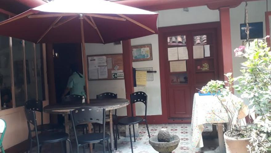 Patio interior de restaurante tradicional, con mesas al aire libre y decoración colorida.