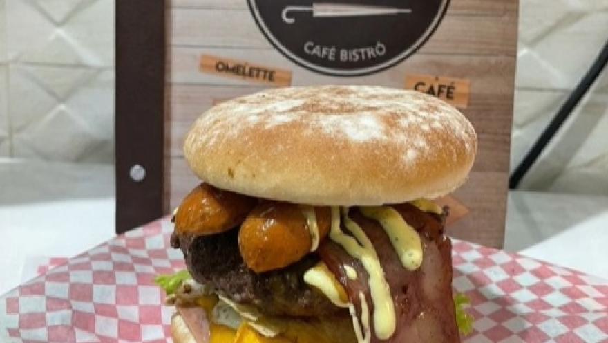 Foto1: Hamburguesa artesanal de Ála' Carachas, servida con carne, queso, vegetales y salsas en un pan artesanal.
