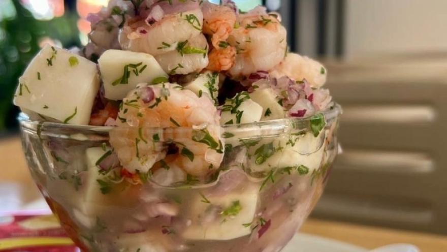 Ceviche de camarones y pescado con cebolla morada, cilantro y limón, servido en una copa de vidrio.