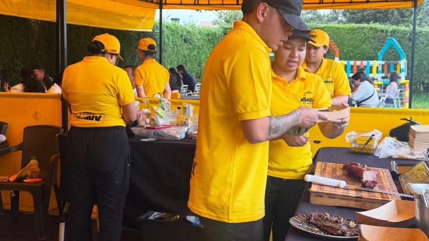 Personal de Asados al Barril prepara y sirve carnes a la parrilla en un ambiente al aire libre, con cortes listos para disfrutar.