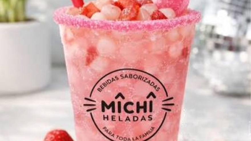 Bebida saborizada de fresa con hielo, fruta fresca y escarchado de color rosa.