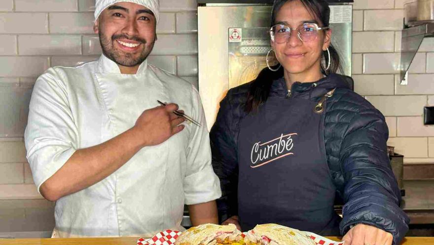 Chef y comensal presentan el sánduche de chicharrón acompañado de papas y salsa de aguacate.