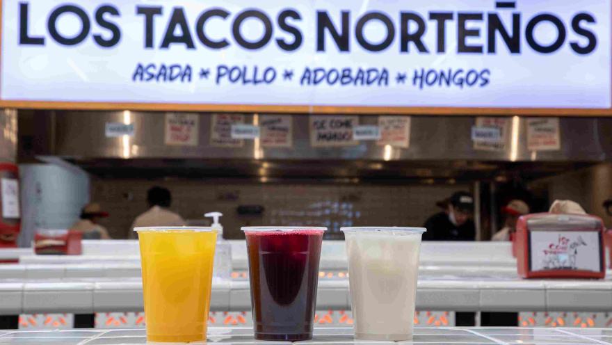  Tres bebidas de colores acompañadas por la barra de Los Tacos Norteños.