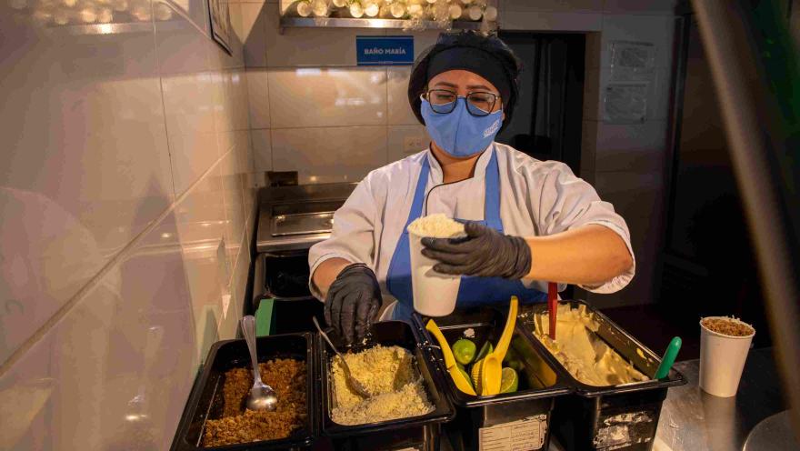  Cocinera prepara esquites con maíz y diferentes ingredientes en la estación de servicio.