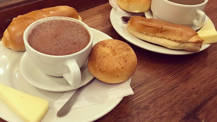 Chocolate caliente acompañado de queso, almojábana y envuelto tradicional.