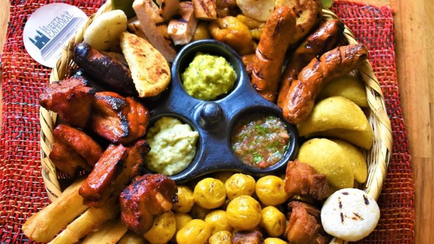 Picada colombiana con carnes, chorizos, arepas, papas, plátano y salsas.