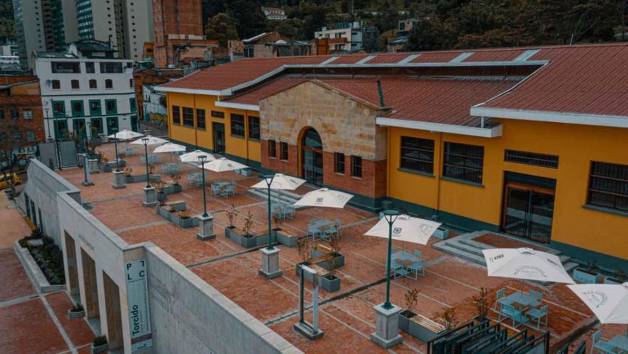 Vista del conjunto arquitectónico del Mercado de la Concordia, rodeado por construcciones tradicionales y las montañas de Bogotá.