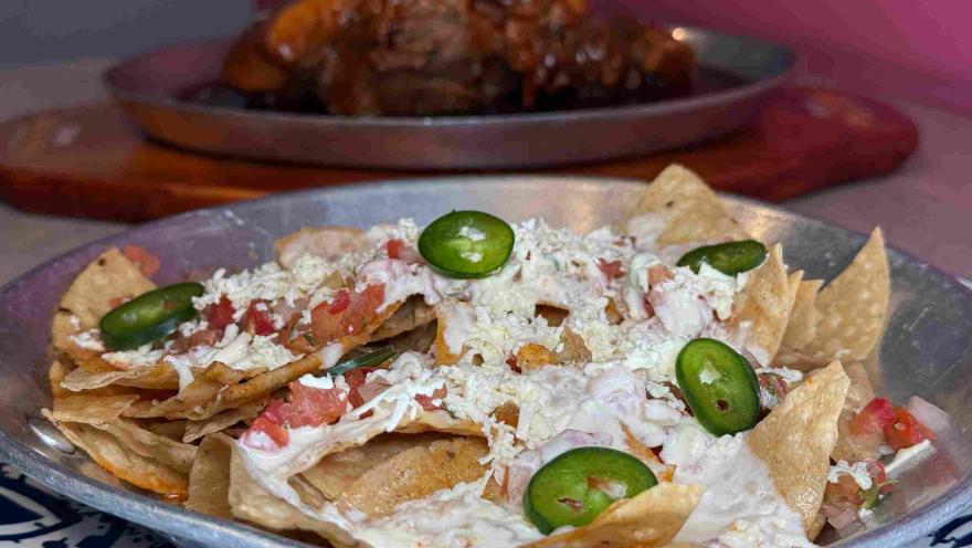 Nachos with sour cream, cheese, pico de gallo, and jalapeño slices.