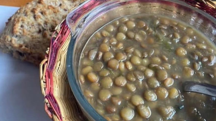 Sopa de lentejas acompañada de pan artesanal.