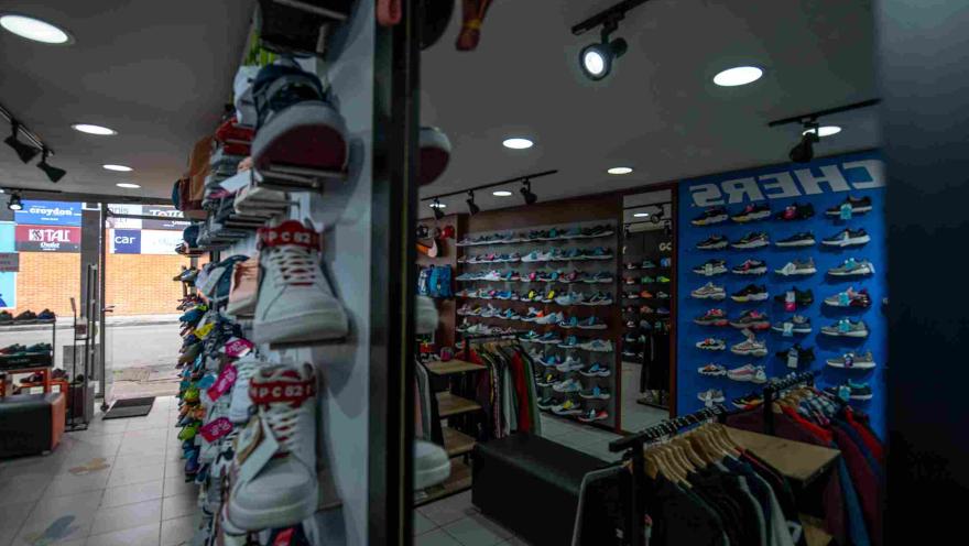 Interior de una tienda deportiva en Floresta Outlet, con una amplia exhibición de zapatillas de diferentes estilos y colores, además de prendas y accesorios organizados en estanterías y exhibidores.