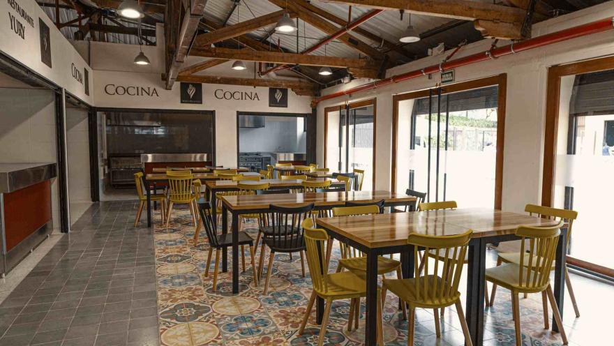Espacio gastronómico del Mercado de la Concordia, con mesas de madera, cocina abierta y detalles que combinan lo tradicional con lo contemporáneo.
