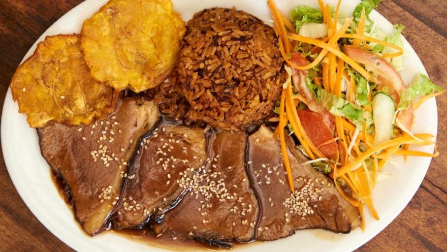  Plato de carne en salsa acompañado de arroz, patacones y ensalada fresca de lechuga, tomate, zanahoria y pepino.