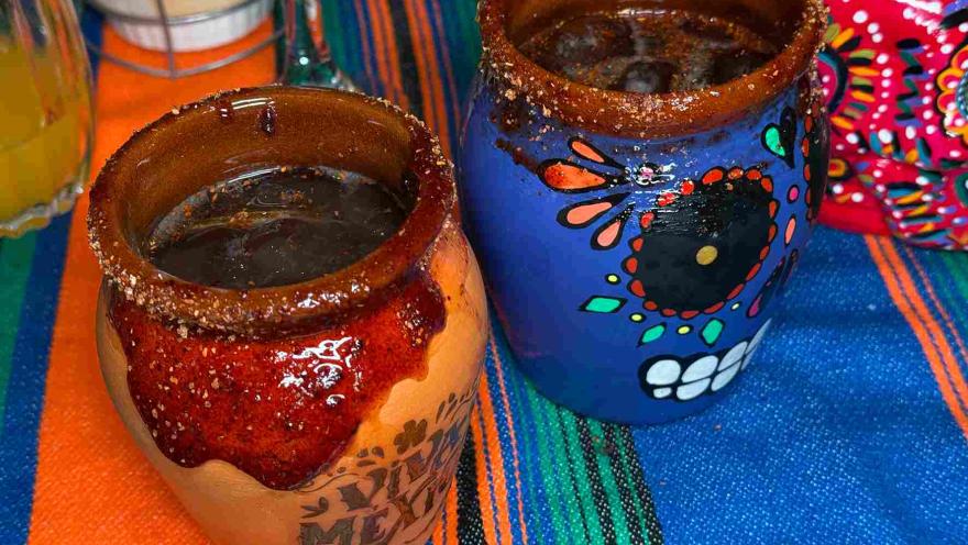 Drinks served in clay cups decorated with Mexican skull motifs.