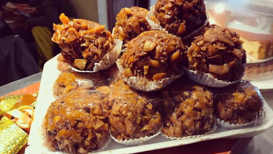 Dulces tradicionales de coco, dorados y caramelizados, exhibidos en una bandeja.