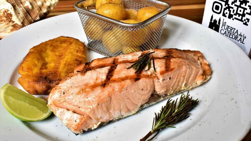 Filete de salmón a la parrilla acompañado de patacón, papas y limón.