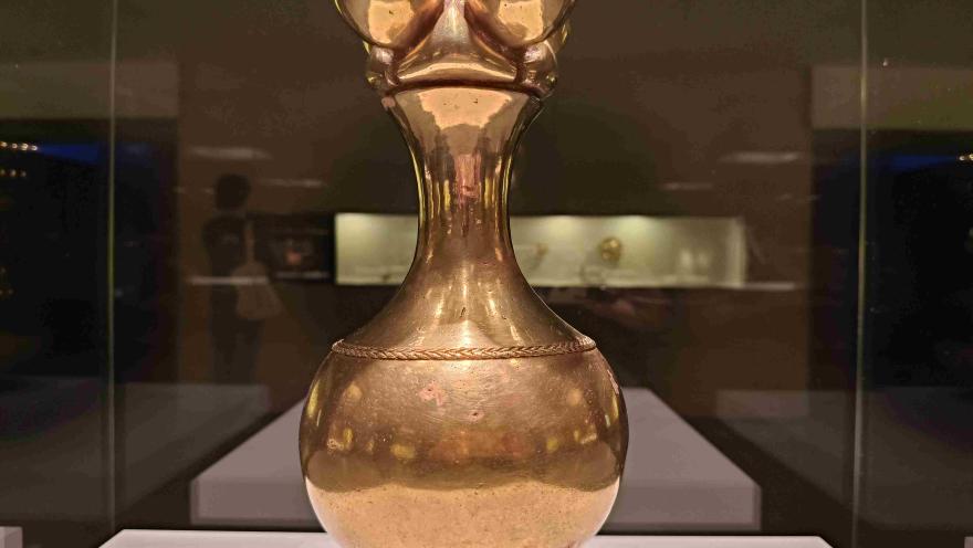 Pieza de orfebrería precolombina en oro, exhibida en una vitrina del Museo del Oro de Bogotá y destacada por su detallado diseño.