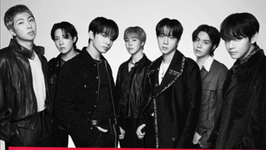Retrato promocional en blanco y negro de los siete integrantes del grupo surcoreano BTS posando juntos.