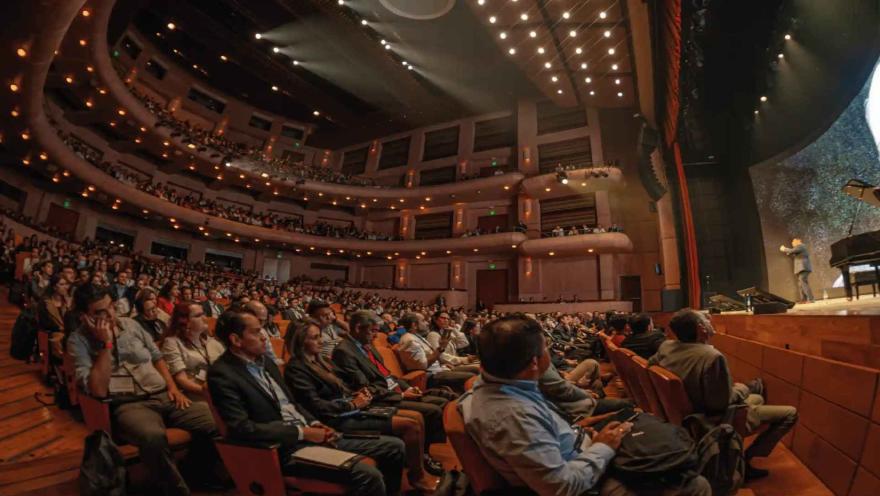 Vista de gran angular del auditorio del Teatro Mayor Julio Mario Santo Domingo lleno durante una conferencia.