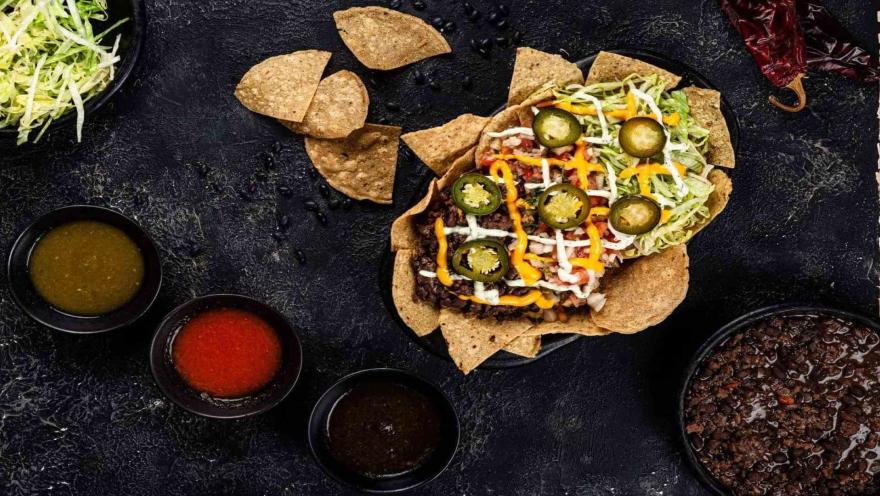 Los Nachos de la casa con birria deshebrada, quesos y jalapeños. Acompañados de 3 salsas épicas.