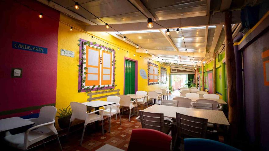  Comedor alargado del restaurante Sazón Costeño iluminado con guirnaldas de luces y paredes coloridas.