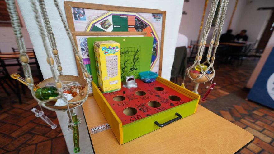 Juego tradicional de rana dispuesto sobre una mesa, acompañado de otros elementos lúdicos.