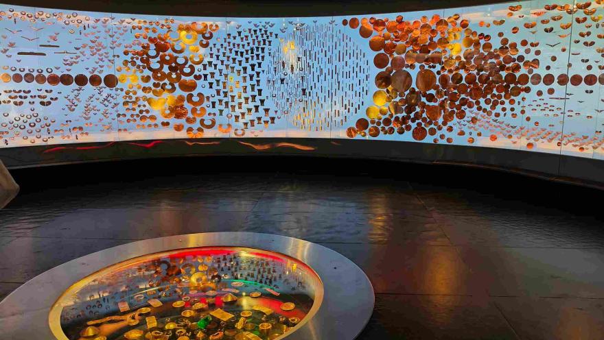 Vista interior de una sala del Museo del Oro, con piezas de orfebrería prehispánica exhibidas en una instalación circular iluminada.