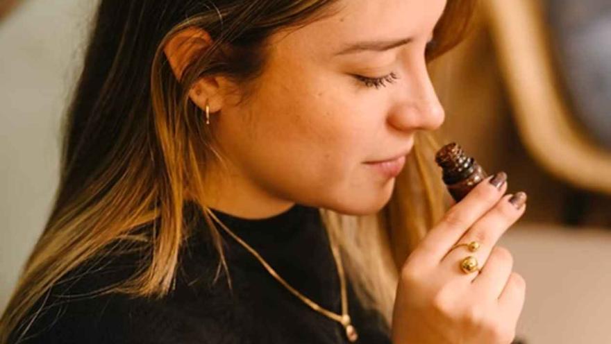 Mujer oliendo un frasco de aroma durante una cata sensorial en el taller de Legado Cacao. 