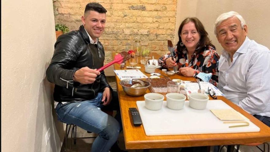 Tres personas sonrientes en una mesa preparando barras de chocolate durante una cata en Legado Cacao. 