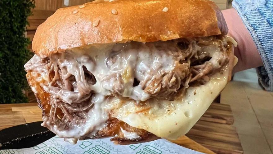 Hamburguesa de pulled pork con abundante queso y salsa, servida en Good Burger.