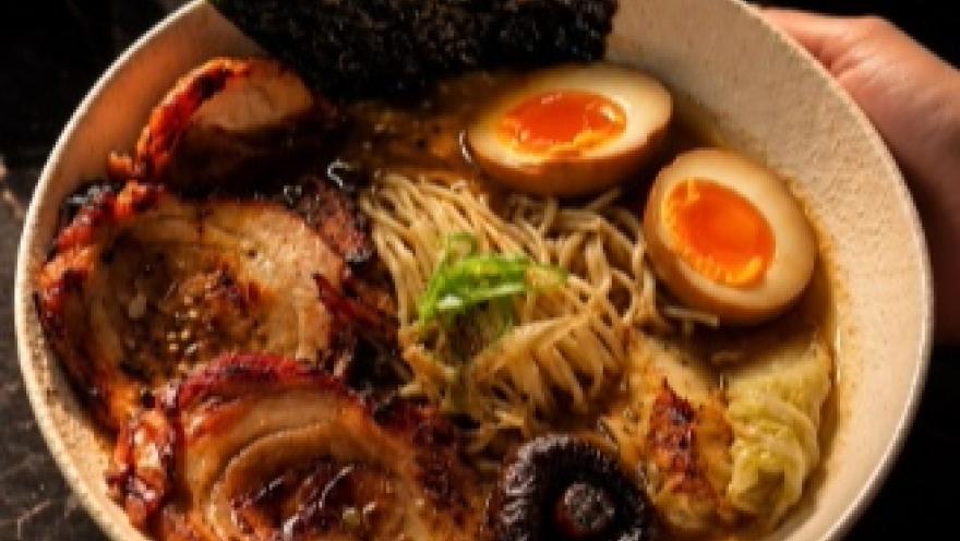 Ramen servido en un tazón, con fideos, cerdo, huevo, hongos y alga nori.