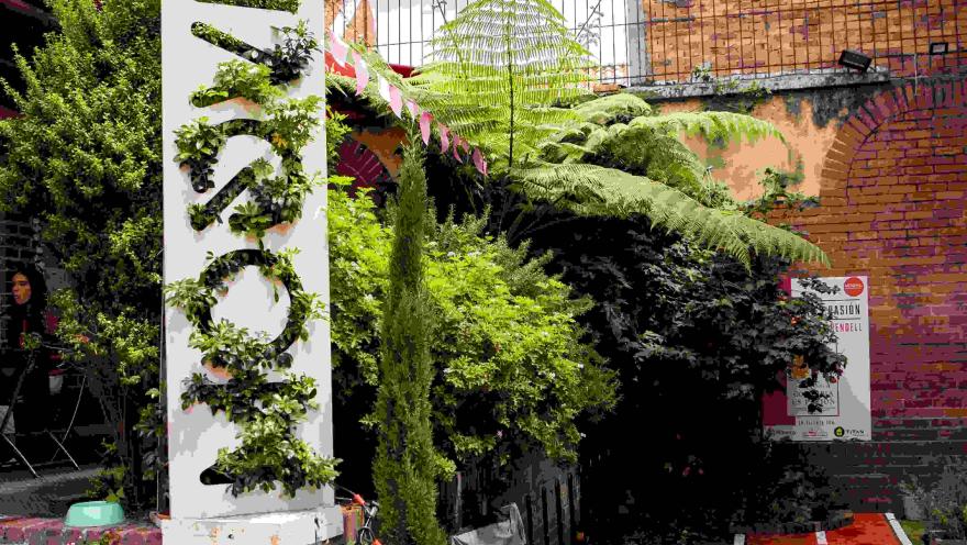  Jardín interior de Moovil, con vegetación, muros de ladrillo y un circuito que evoca la experiencia de pedalear por Bogotá.