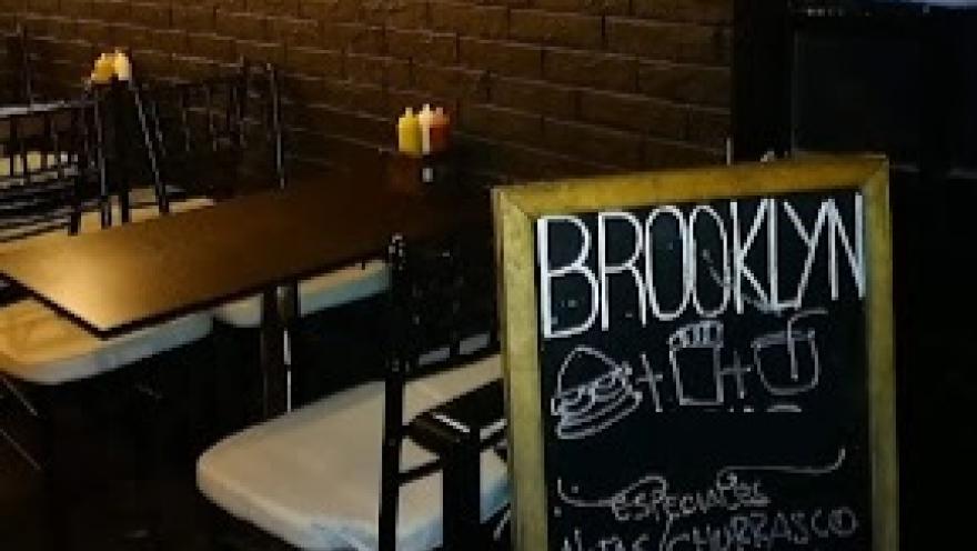  Interior de Brooklyng, con mesas y una pizarra que anuncia sus especialidades.