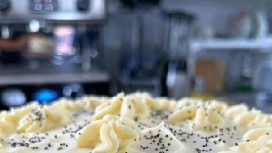 Postre cremoso decorado con crema y semillas de amapola.