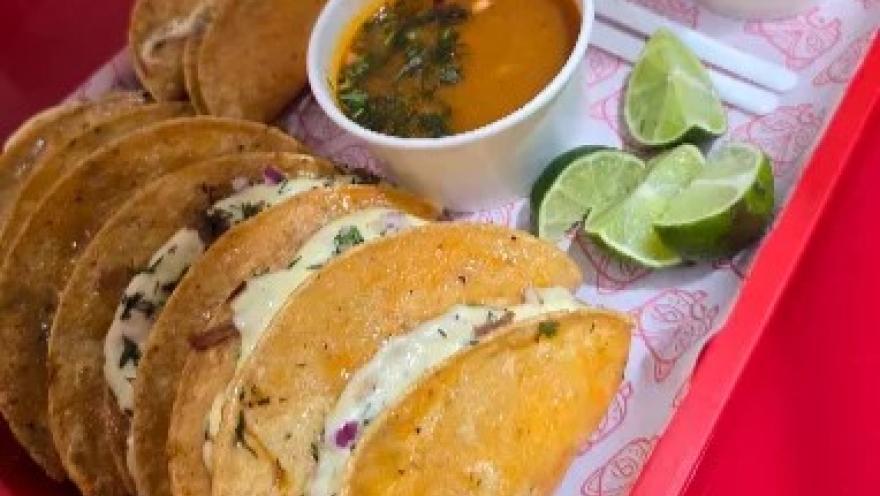 Selección de tacos de birria acompañados de consomé y limón.