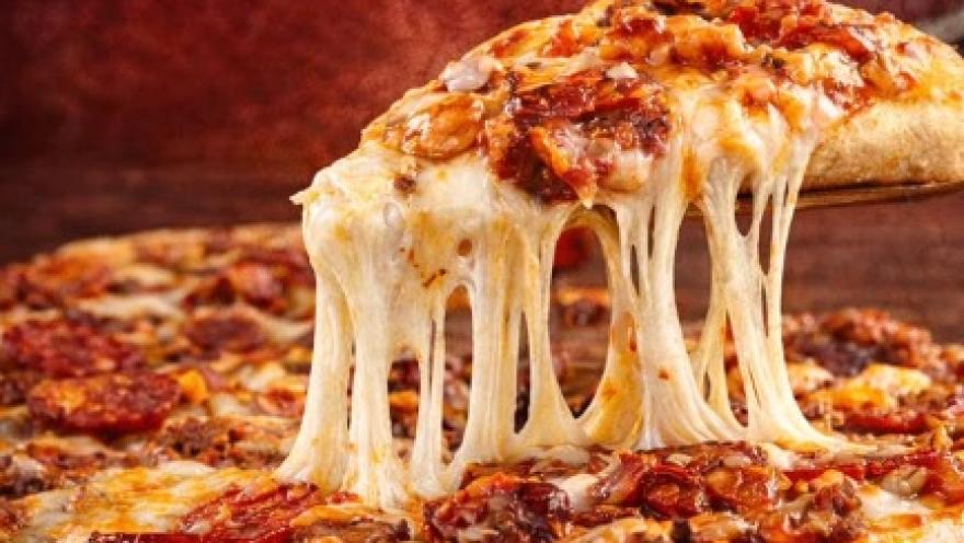  Pizza con queso derretido y trozos de carne, servida recién horneada.