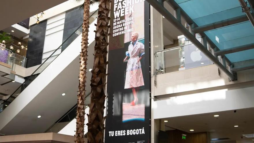 Una gran pantalla digital, escaleras y palmeras integradas al interior crean un ambiente moderno y dinámico en el Centro Comercial El Retiro, donde la arquitectura y la vida urbana se encuentran.
