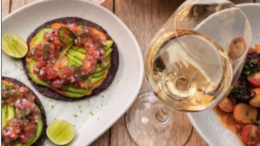Tostadas de aguacate con pico de gallo y limón, acompañadas de una copa de vino blanco en 80 Sillas.