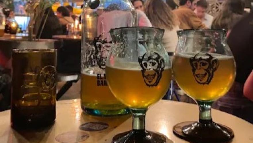 Cervezas artesanales de El Mono Bandido servidas en copas y vasos, en un ambiente animado y concurrido.