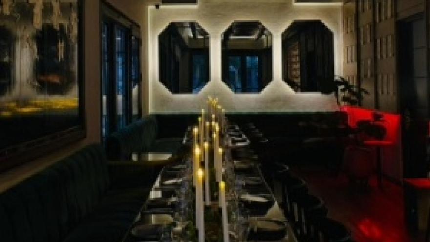 Comedor elegante y sofisticado, con mesas dispuestas para grupos, iluminación tenue y detalles decorativos contemporáneos.